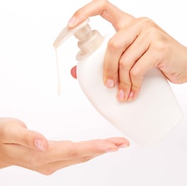 hands-applying-white-liquid-soap crop